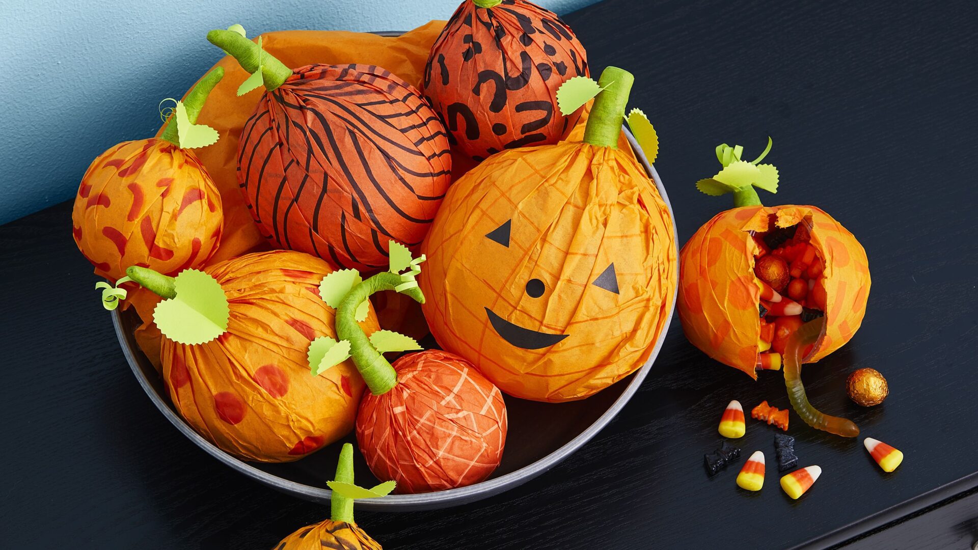 Paper-mache candy holders/dispensers for trick or treaters. Tissue paper (or newspaper), water, elmers' glue (saturate paper with water and glue, cover balloon for shape, pop balloon when glue dries)